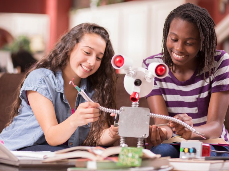 Zwei junge Frauen bauen einen Roboter.