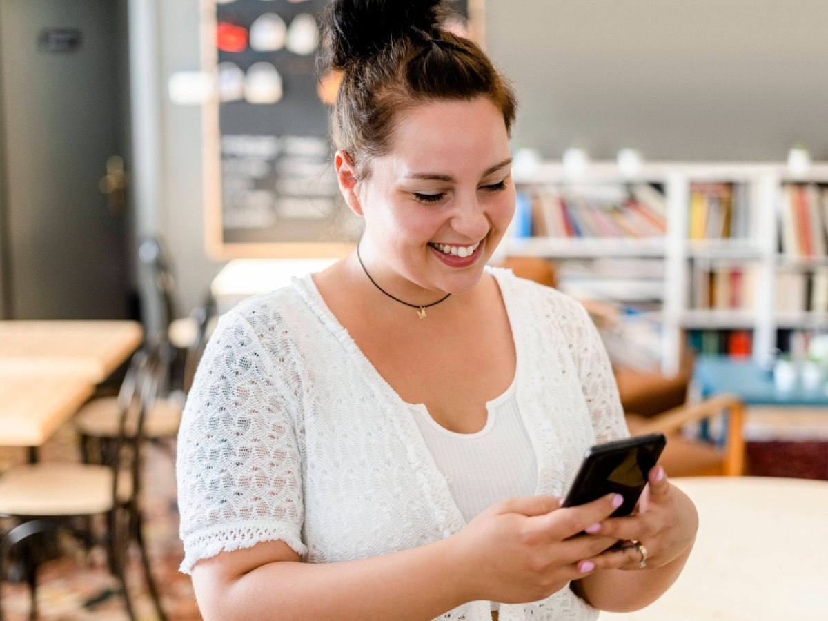 Frau lächelt mit Handy