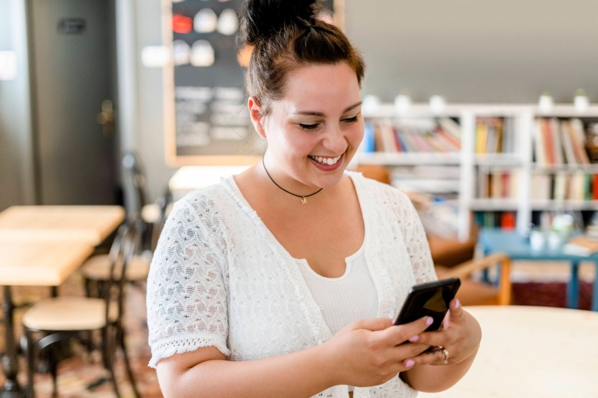 Frau lächelt mit Handy