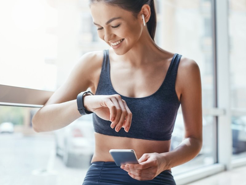 Frau mit Smartwatch und Handy