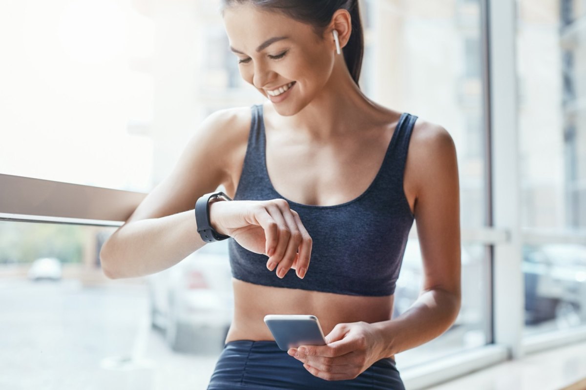 Frau mit Smartwatch und Handy