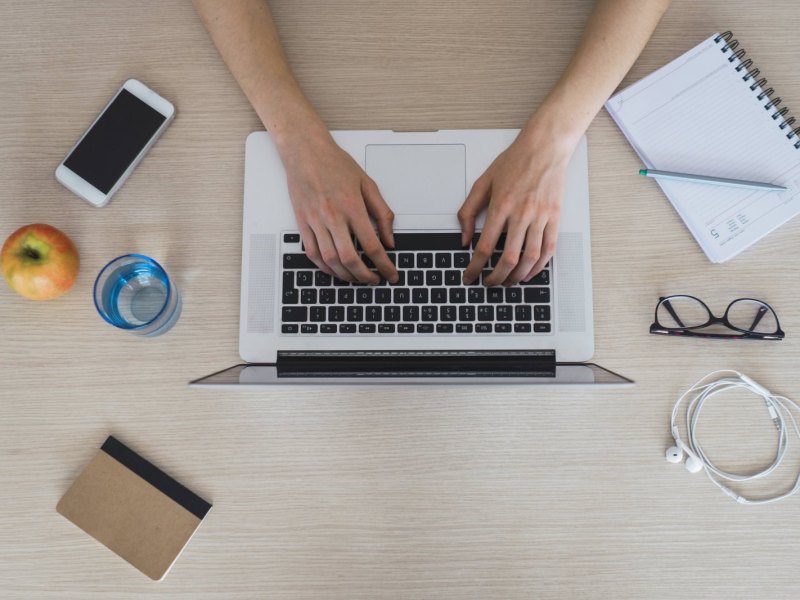 Mann tippt auf Laptop-Tastatur