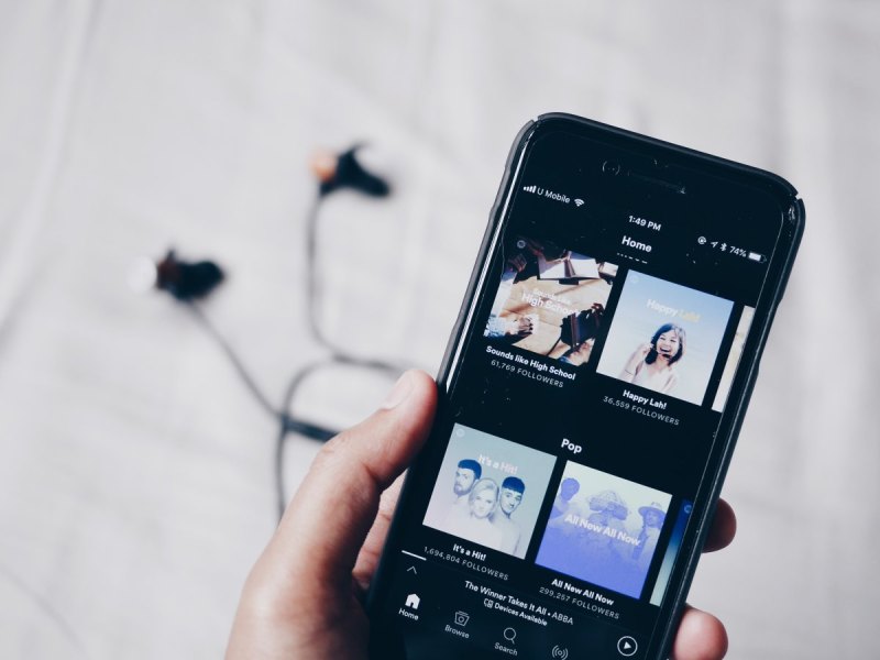 Person hält Smartphone mit Spotify