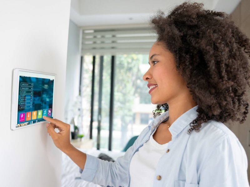 Frau mit Tablet an der Wand