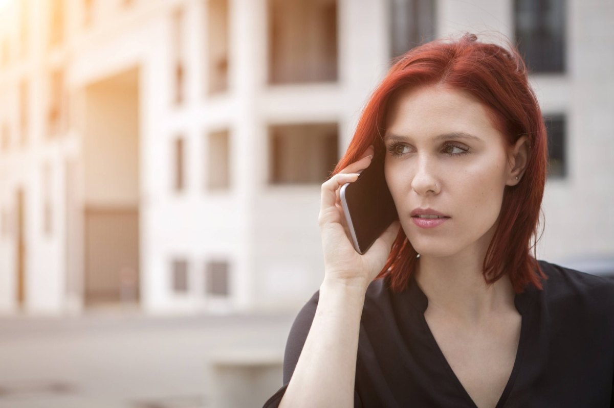 Junge Frau hat das Handy am Ohr und telefoniert