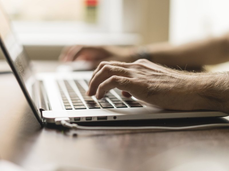 Person tippt auf Laptop-Keyboard