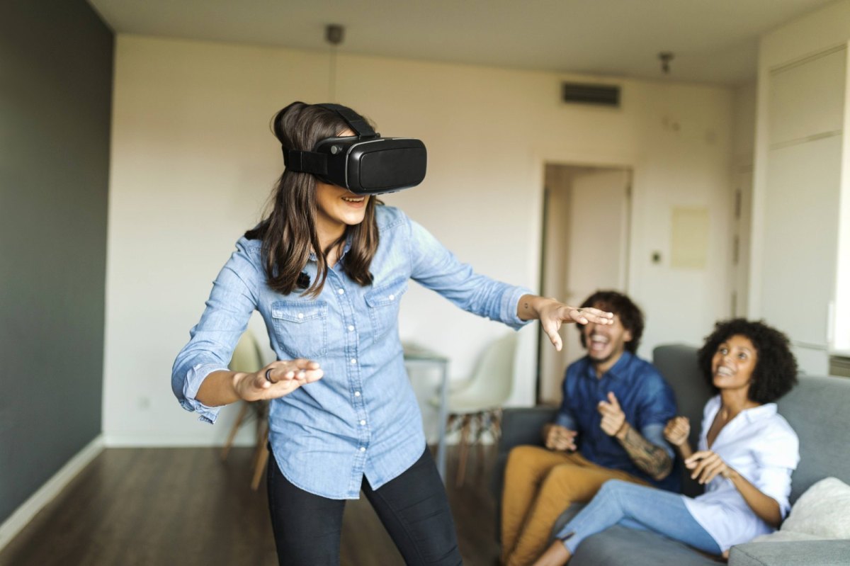 Frau mit einer VR-Brille und Freunden.