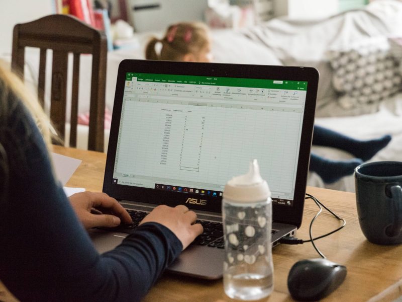 Frau sitzt am Laptop und arbeitet mit Excel