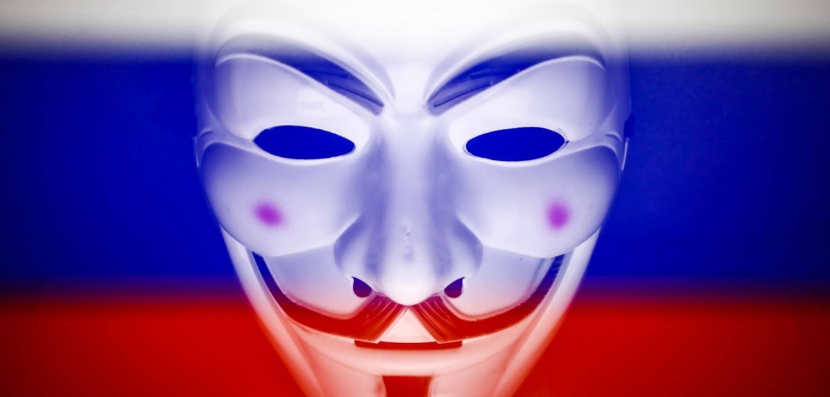 Anonymous-Maske vor einer russischen Flagge.