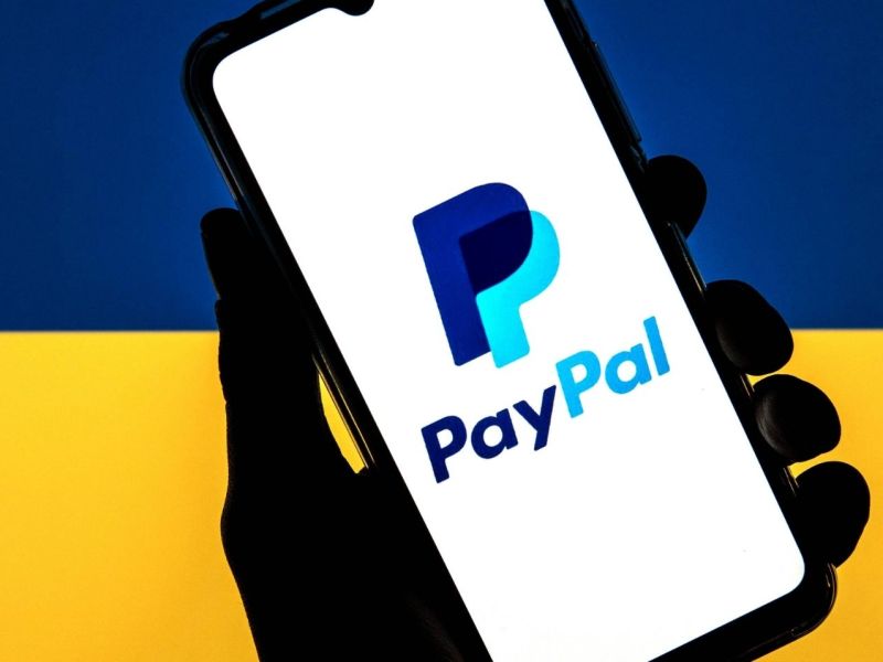 PayPal-Logo vor der Ukraine-Flagge.