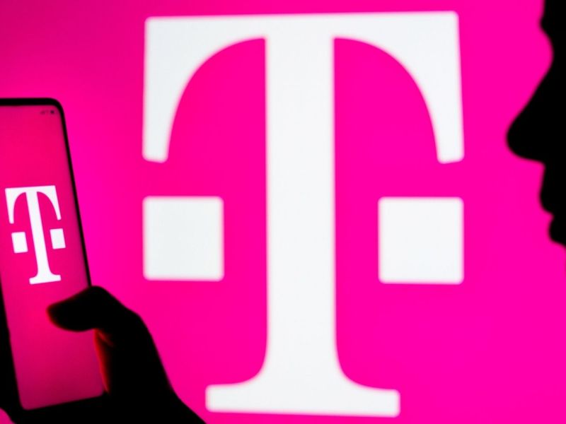 Person mit Smartphone vor einem Telekom-Logo