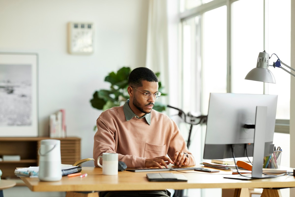 Mann sitzt am PC und arbeitet