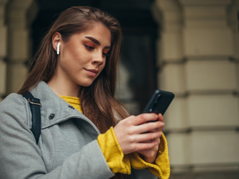 Frau mit AirPods und iPhone