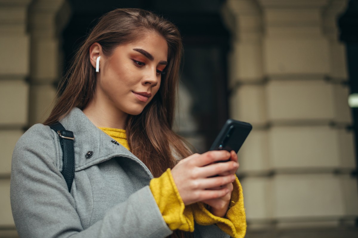 Frau mit AirPods und iPhone