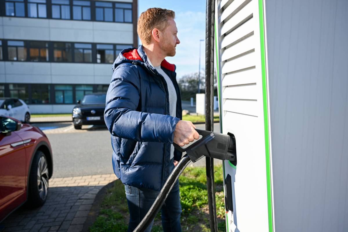 Mann lädt Auto an Wallbox