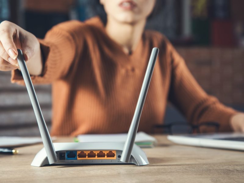 Frau stellt WLN-Router-Antenne ein