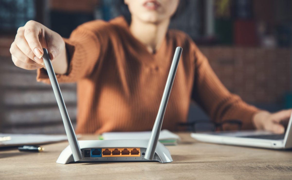 Frau stellt WLN-Router-Antenne ein