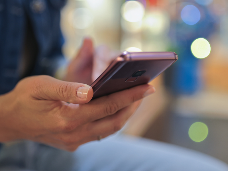 Person hält Smartphone in der Hand.