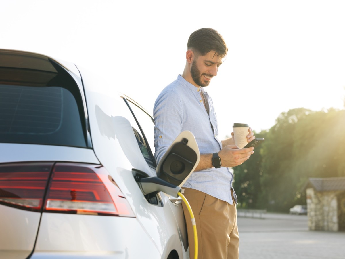 Mann lädt sein Elektroauto an der Ladesäule