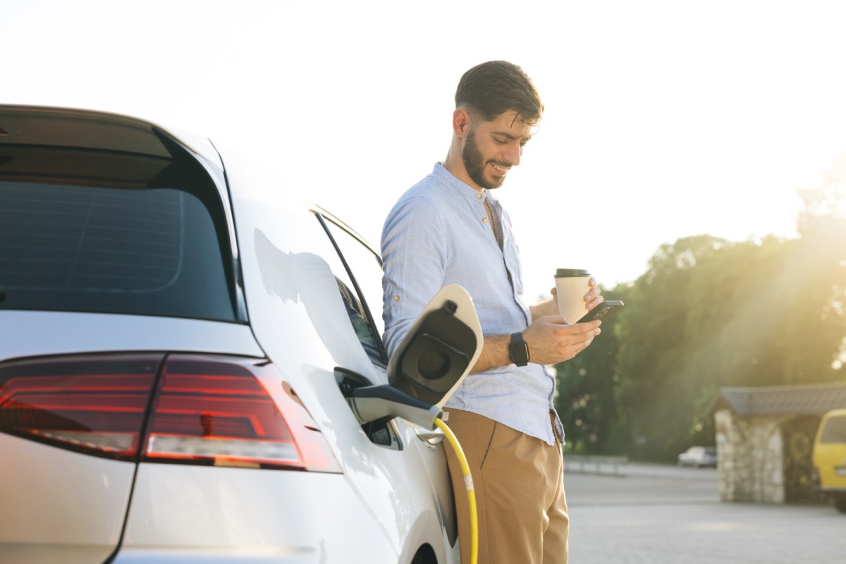 Mann lädt sein Elektroauto an der Ladesäule