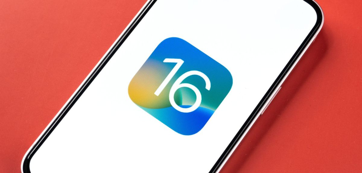 Handy mit dem Logo für iOS 16 auf dem Display.