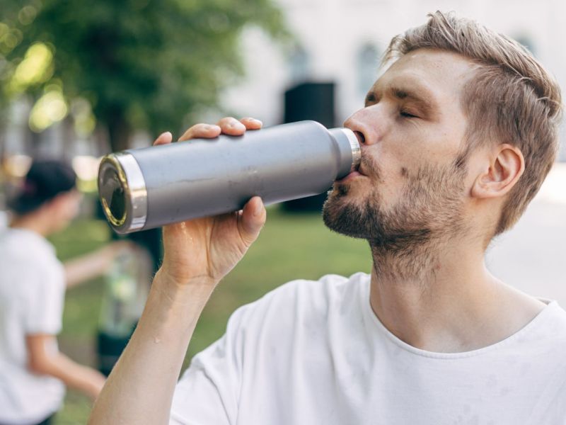 Mann trinkt aus Flasche