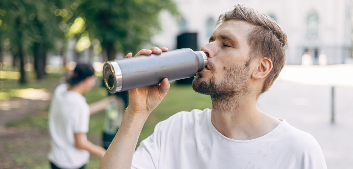 Mann trinkt aus Flasche