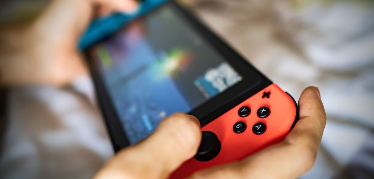 Person hält eine Nintendo Switch in Händen und spielt.