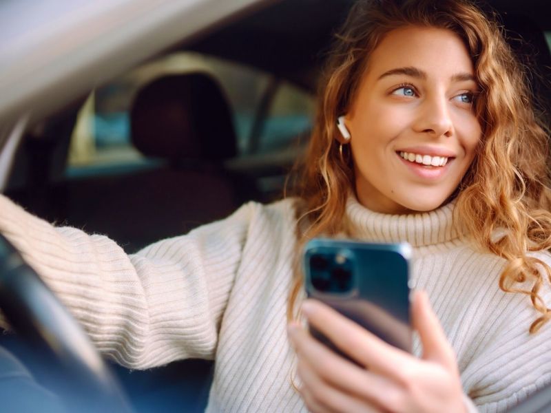 Frau mit Handy im Auto