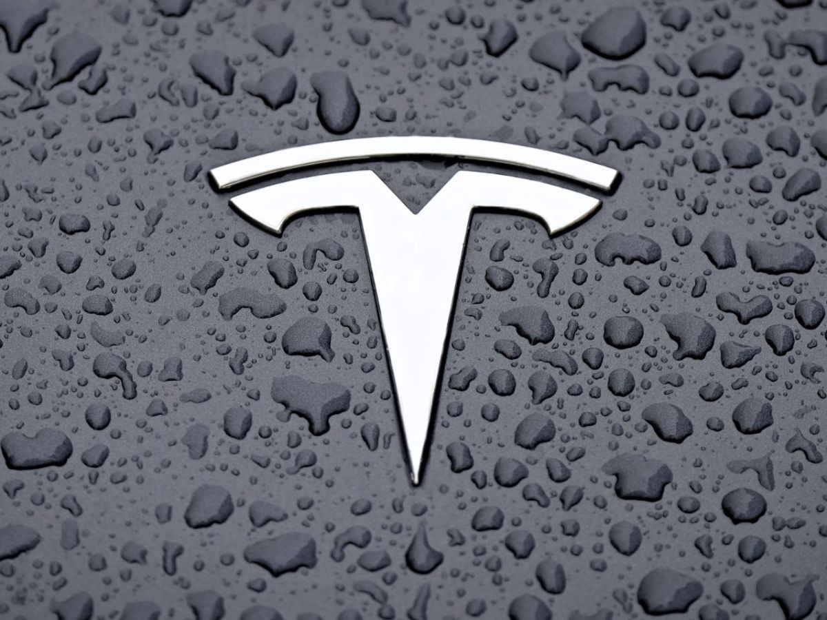 Tesla-Logo auf einer feuchten Oberfläche.