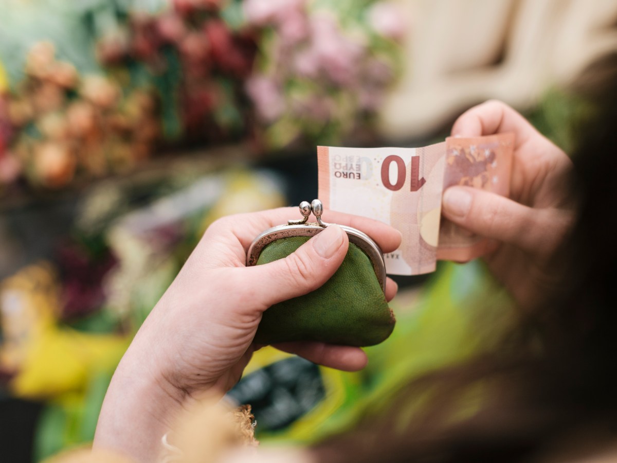 Eine Frau zieht einen 10-Euro-Schein aus dem Portemonnaie.