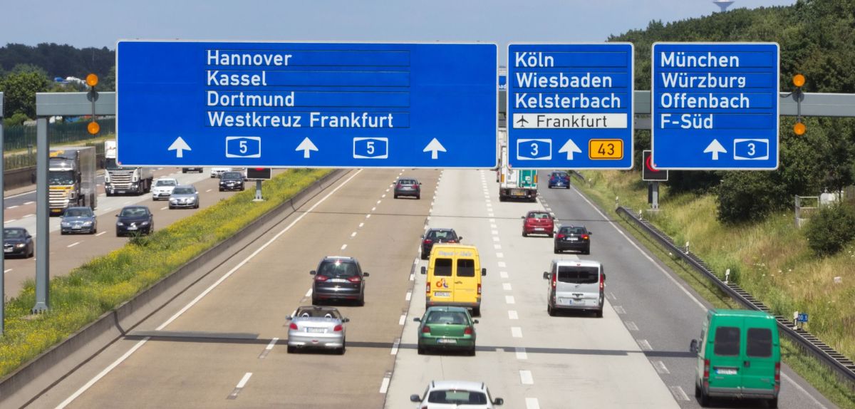 Autos auf der Autobahn samt vieler Verkehrsschilder