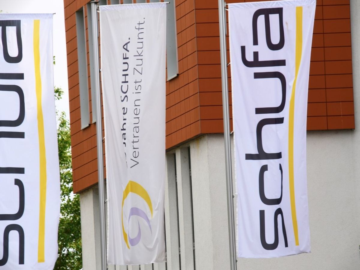 Schufa-Logo vor Gebäude.