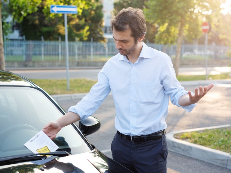 Mann hat Knöllchen am Auto