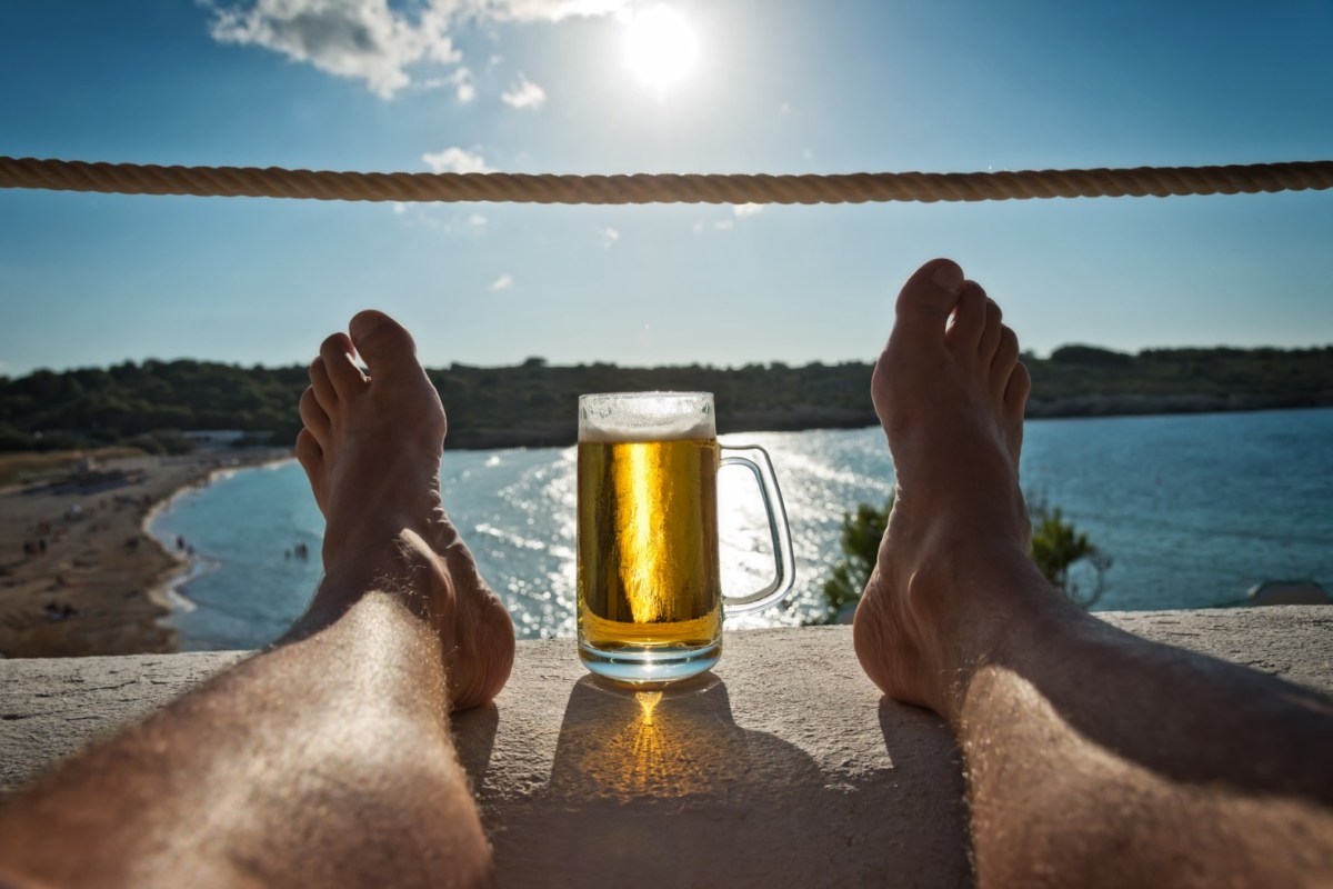 Bier am Meer zwischen zwei Füßen