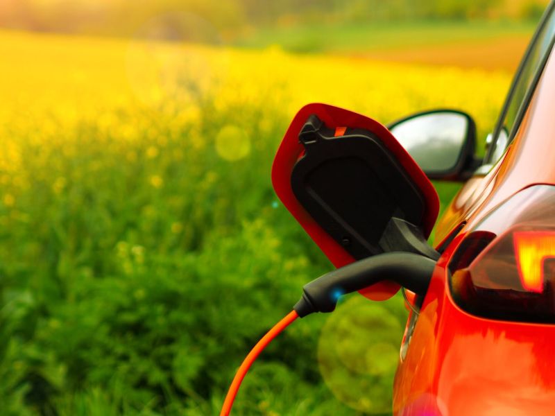 Ein Elektroauto wird bei gutem Wetter aufgeladen.