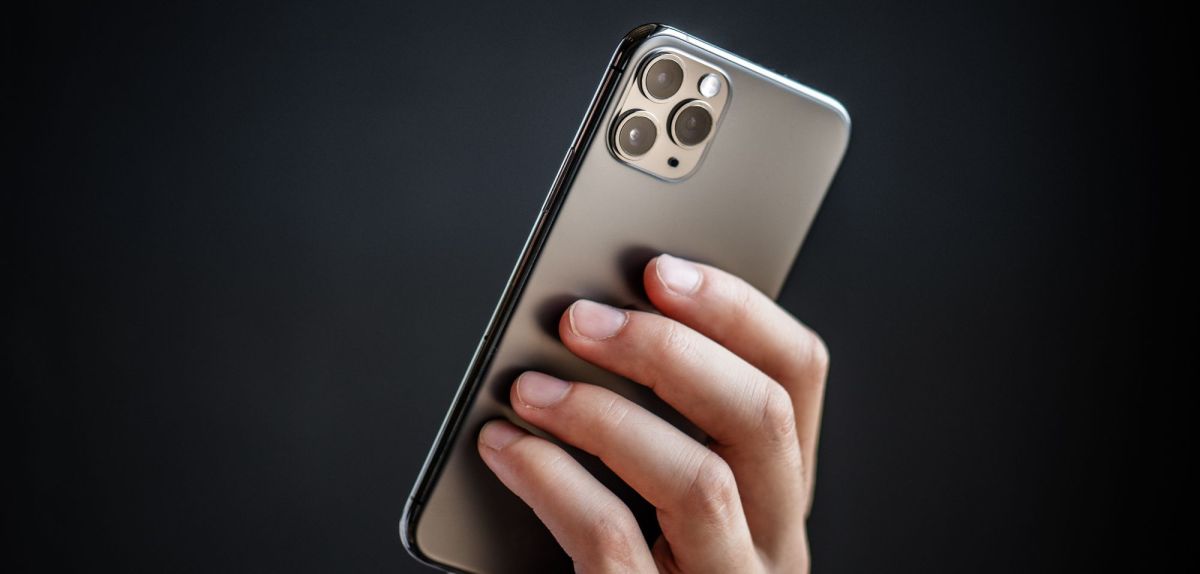 Person hält ein iPhone 11 Pro in der Hand.