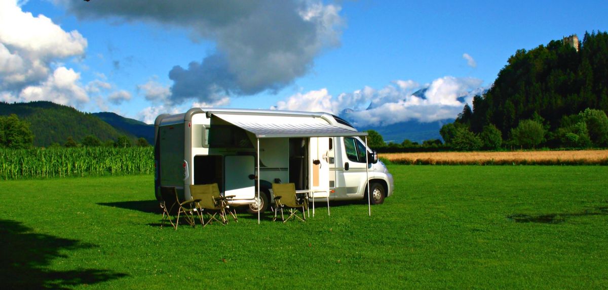 Wohnmobil campt autark auf einer Wiese