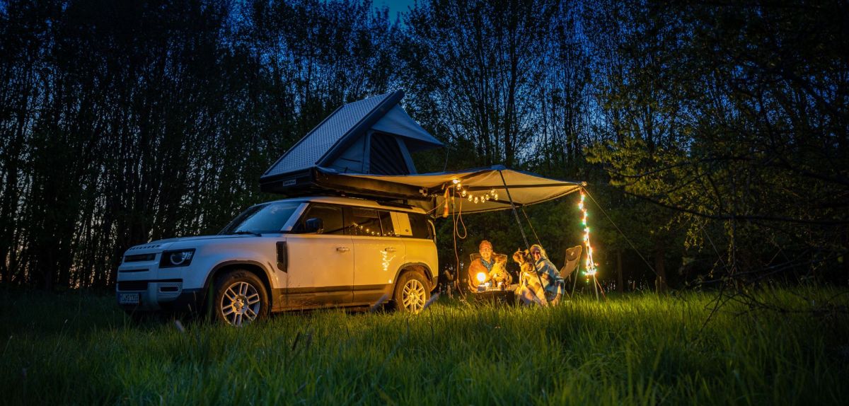 Autozelte am Auto befestigt mit Campern darunter