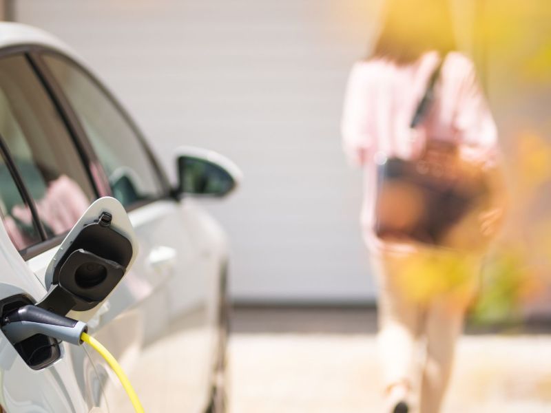 Frau entfernt sich von einem Elektroautos