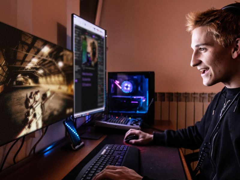 Mann sitzt vor einem Monitor und spielt einen Shooter