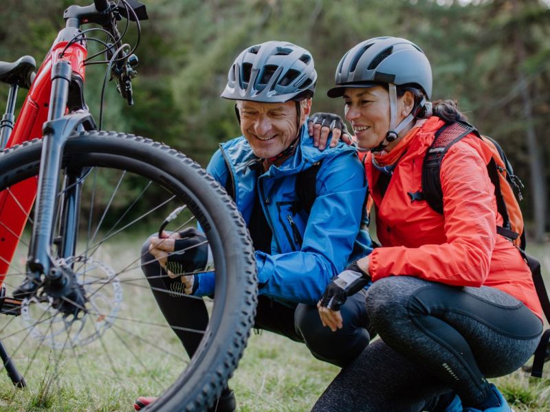 Zwei Personen knien neben einem Fahrrad