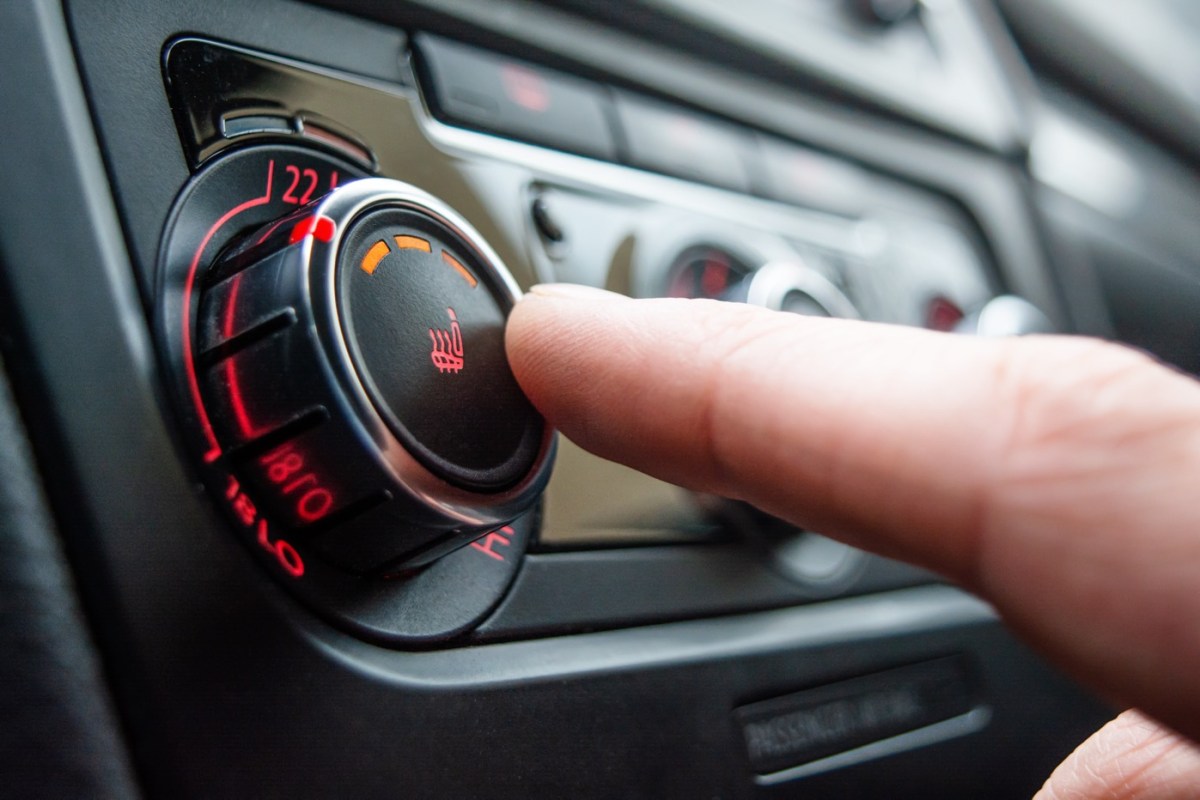 Person drückt den Knopf für die Autoheizung