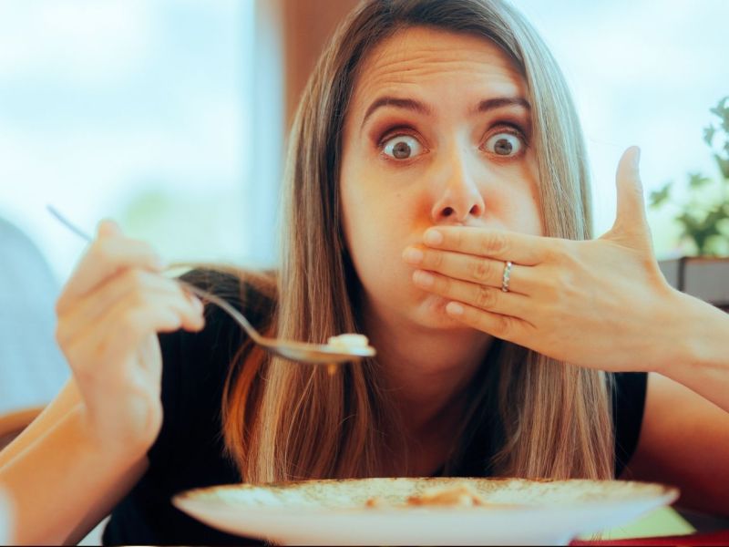 Frau isst im Restaurant und dann wird ihr schlecht.