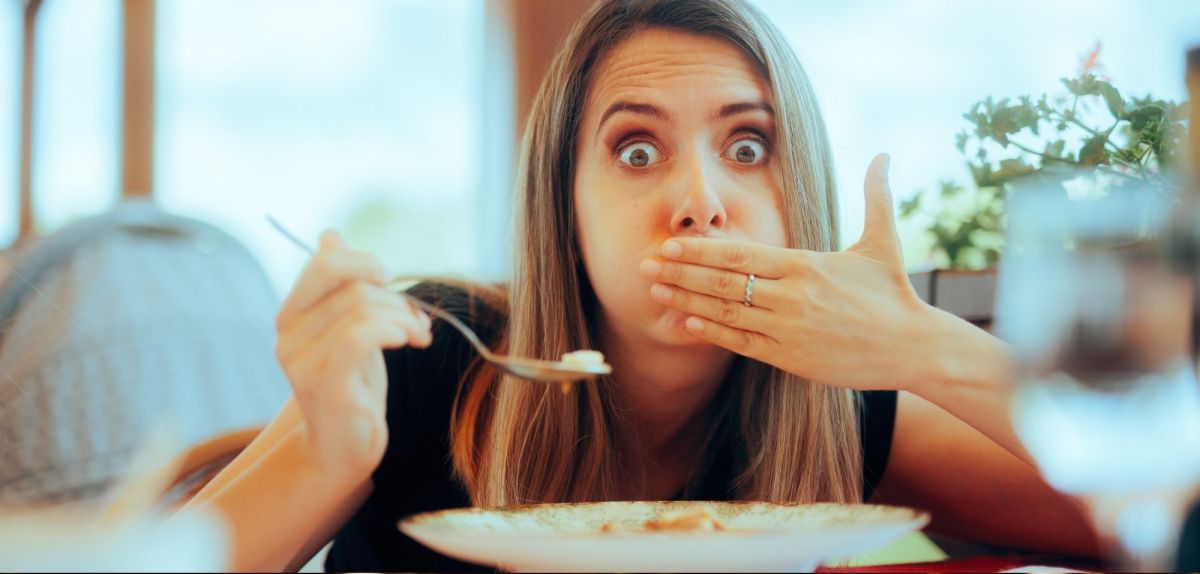 Frau isst im Restaurant und dann wird ihr schlecht.