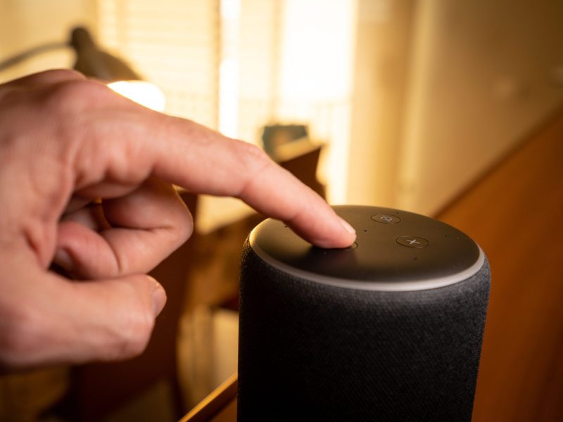 Hand tippt auf Amazon Echo.