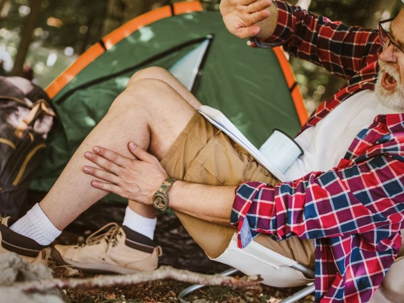 Camper schägt eine Mücke