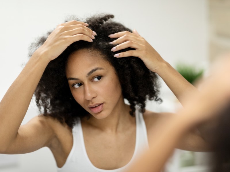 Frau sucht nach grauen Haaren