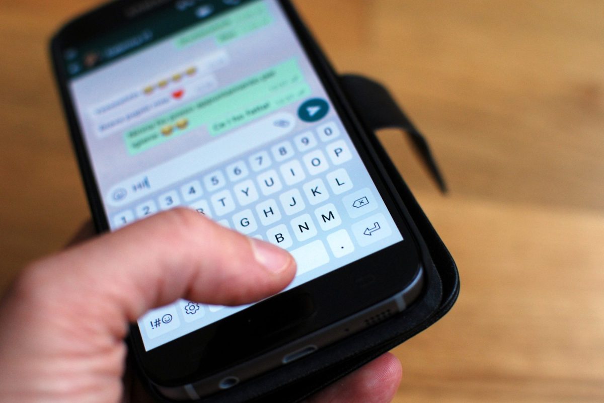 Eine Person tippt im WhatsApp Chat auf ihrem Smartphone.