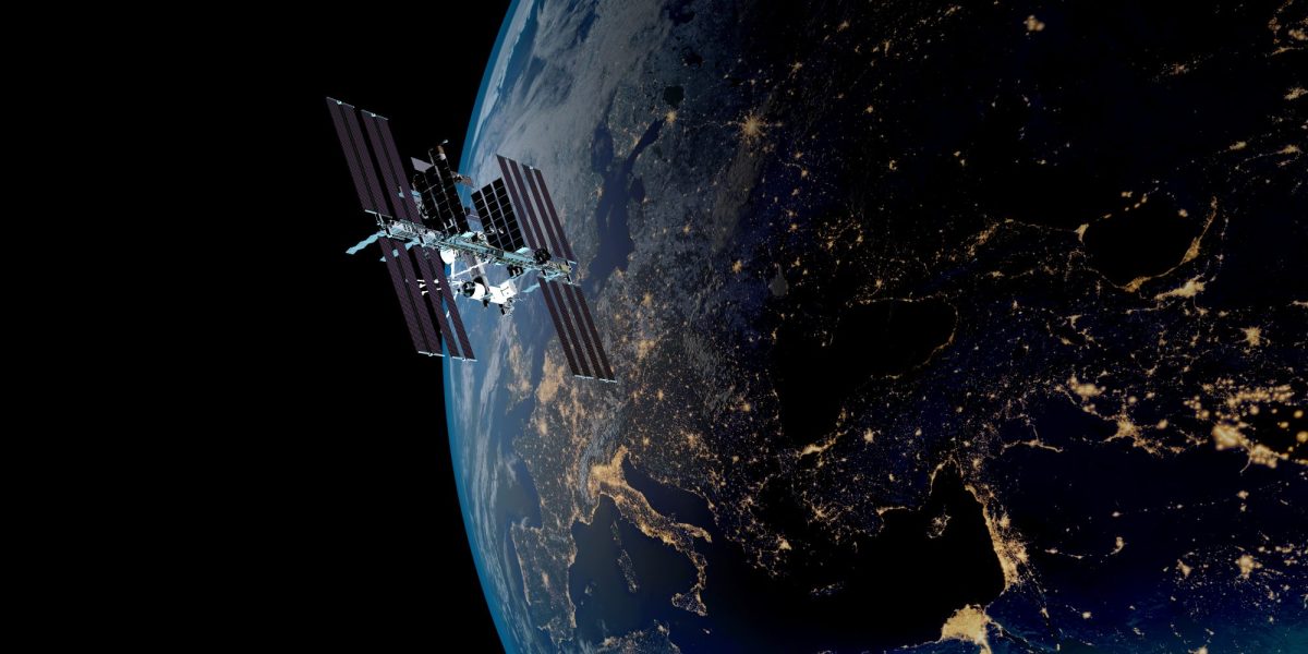 Die ISS kreist über den Lichtern der Erde.